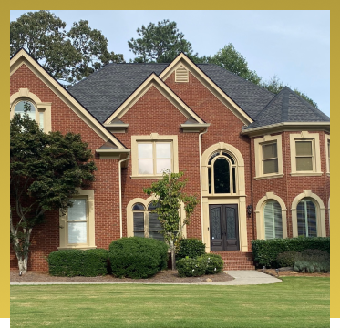 Beautiful two-story brick house with arched windows and manicured landscaping