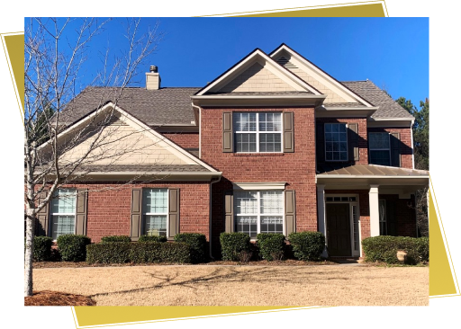 Large two-story brick house with white trim windows and front porch columns