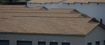 Residential house with brown asphalt shingle roof and gray siding exterior