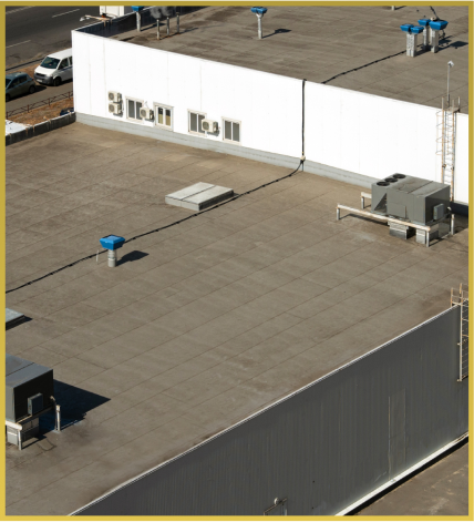Aerial view of white industrial building with HVAC equipment on flat rooftop