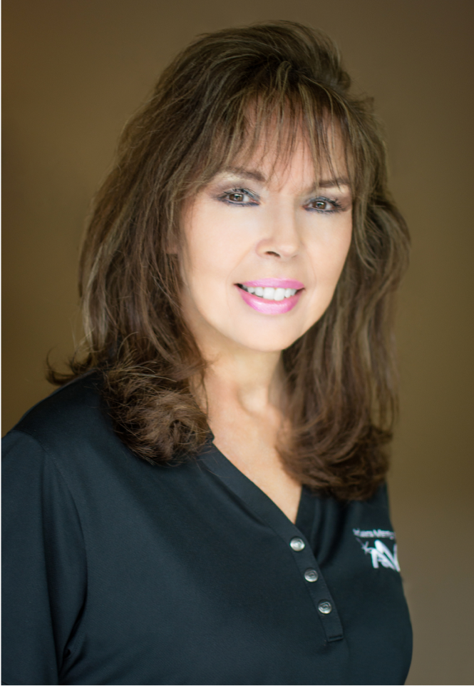 Professional woman with layered brown hair and bangs wearing dark navy polo shirt