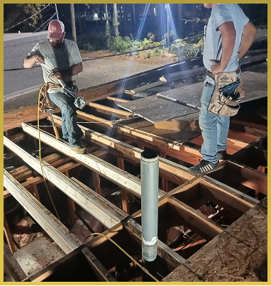 Two construction workers building wooden deck frame with support beams outdoors